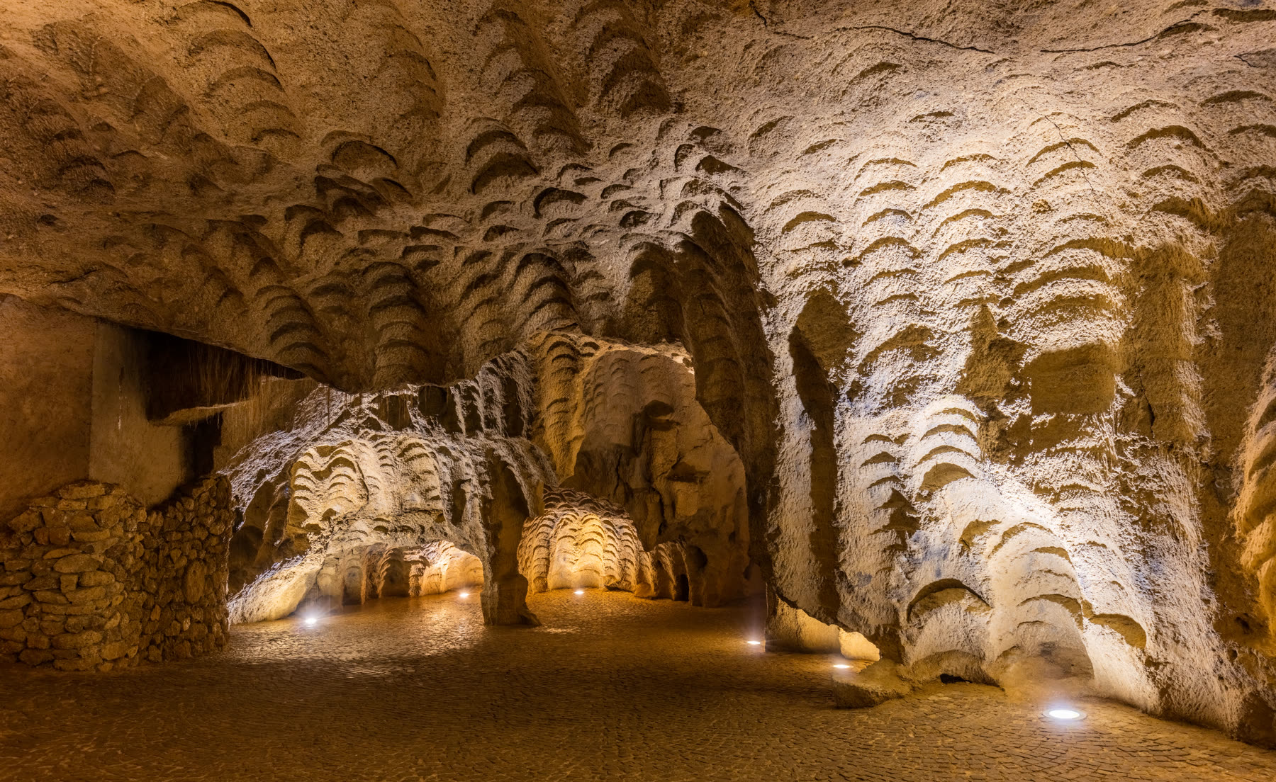The cobblestone floor and quarry-marked ceiling inside the Caves of Hercules