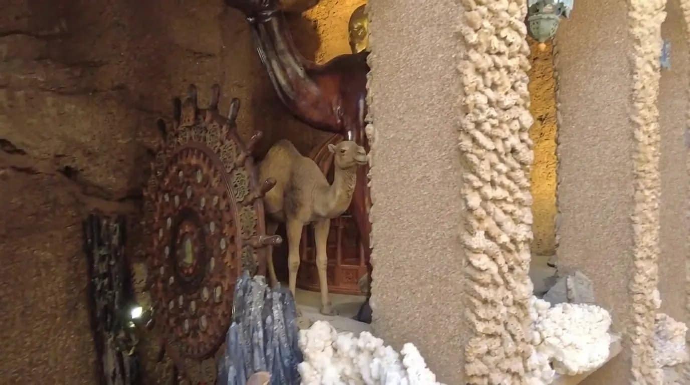 Una escultura de camello de madera y una rueda de madera tallada en la sala decorada de las cuevas de Hércules